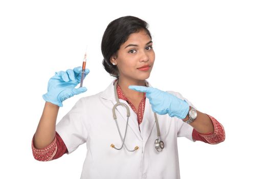 A female doctor with a stethoscope is holding an Injection or Syringe.