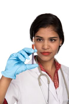 A female doctor with a stethoscope is holding an Injection or Syringe.