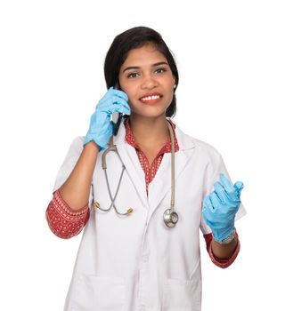 Female doctor with stethoscope talking on mobile phone on white background