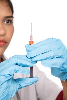 A female doctor with a stethoscope is holding an Injection or Syringe.