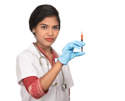 A female doctor with a stethoscope is holding an Injection or Syringe.