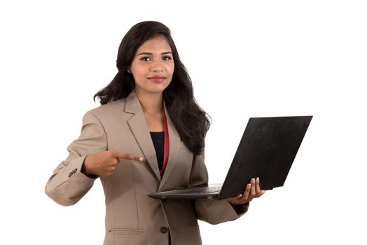 Happy excited business woman holding laptop and pointing on it isolated on a white background