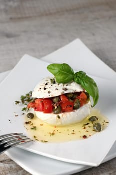 Mozzarella stuffed tomatoes with capers, seasoned   spices and basil in oil