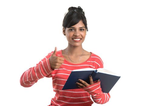 Pretty young girl holding book and posing on white background