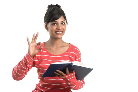 Pretty young girl holding book and posing on white background