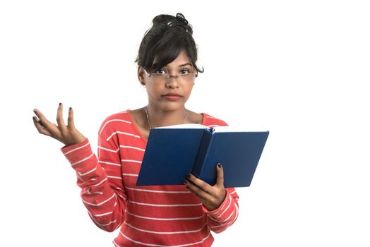 Pretty young girl holding book and posing on white background