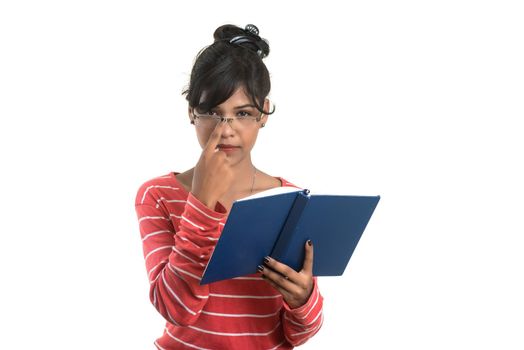 Pretty young girl holding book and posing on white background