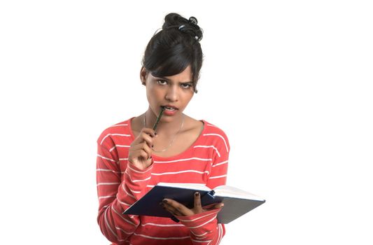 Pretty young girl holding book and posing on white background