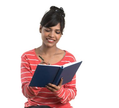 Pretty young girl holding book and posing on white background