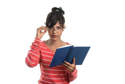 Pretty young girl holding book and posing on white background