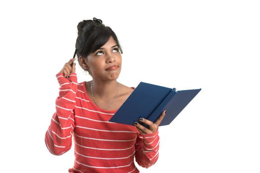 Pretty young girl holding book and posing on white background