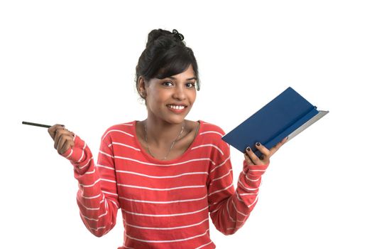 Pretty young girl holding book and posing on white background