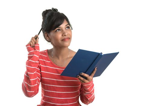 Pretty young girl holding book and posing on white background