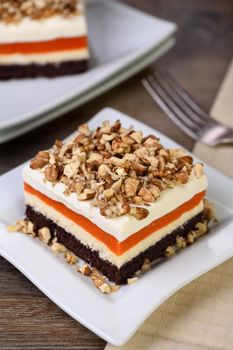 Pumpkin pie - light, creamy dessert with cheese cream and pumpkin layers topped with chopped nuts