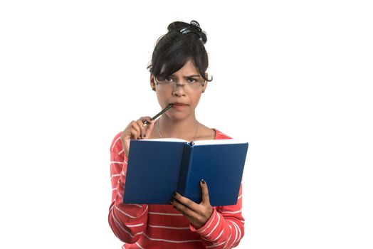 Pretty young girl holding book and posing on white background