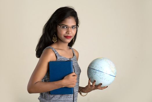 Young girl student holding book with globe on white background. Education in high school university college concept