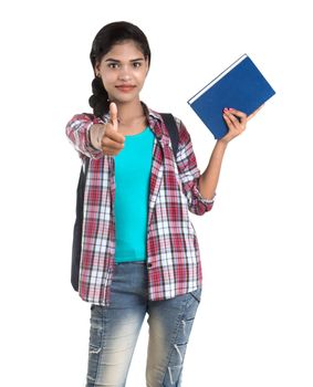young Indian woman with backpack standing and holding notebooks, posing on a white background.