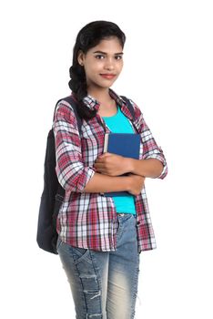 young Indian woman with backpack standing and holding notebooks, posing on a white background.