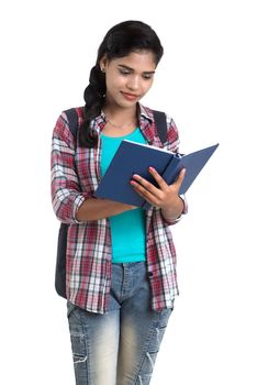 young Indian woman with backpack standing and holding notebooks, posing on a white background.