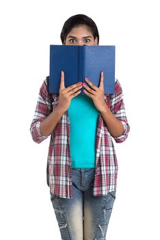 young Indian woman with backpack standing and holding notebooks, posing on a white background.