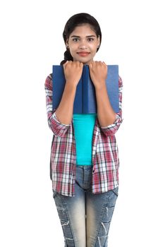 young Indian woman with backpack standing and holding notebooks, posing on a white background.