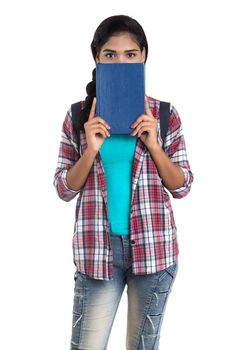 young Indian woman with backpack standing and holding notebooks, posing on a white background.