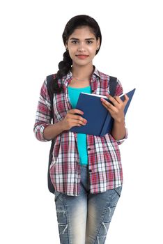 young Indian woman with backpack standing and holding notebooks, posing on a white background.