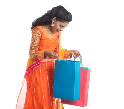 Beautiful Indian young girl holding shopping bags while wearing traditional ethnic wear. Isolated on a white background