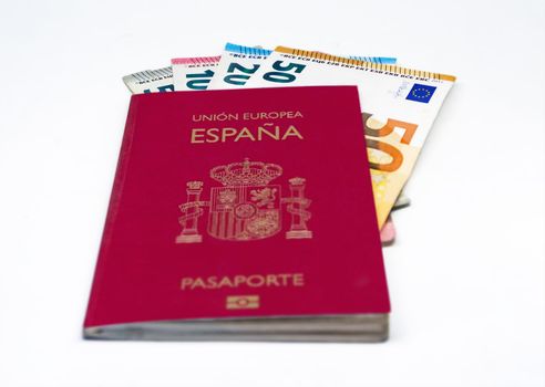 Spanish travel passport with some euro banknotes isolated on a white background. European Union and single currency. Travel and cash