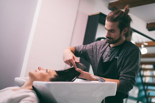 Young woman getting new hairstyle at professional hair styling saloon.