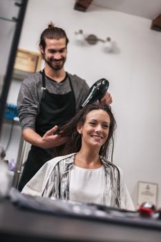 Young woman getting new hairstyle at professional hair styling saloon.