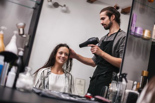 Young woman getting new hairstyle at professional hair styling saloon.