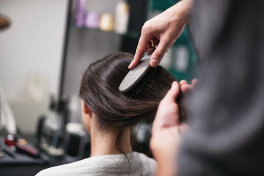 Young woman getting new hairstyle at professional hair styling saloon.