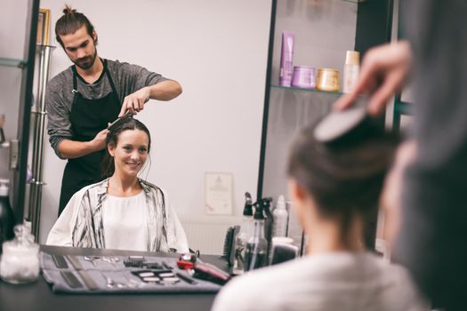 Young woman getting new hairstyle at professional hair styling saloon.