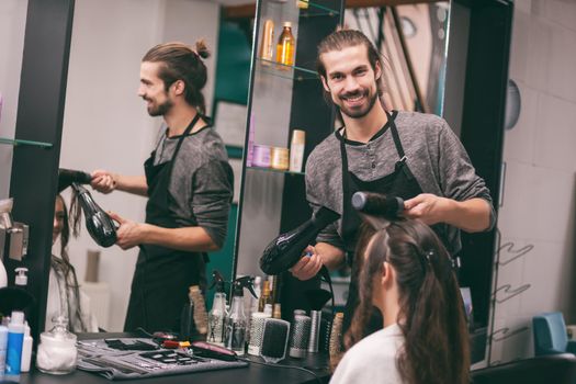 Young woman getting new hairstyle at professional hair styling saloon.