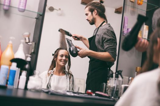 Young woman getting new hairstyle at professional hair styling saloon.