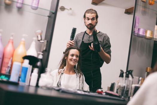 Young woman getting new hairstyle at professional hair styling saloon.