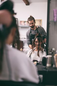 Young woman getting new hairstyle at professional hair styling saloon.