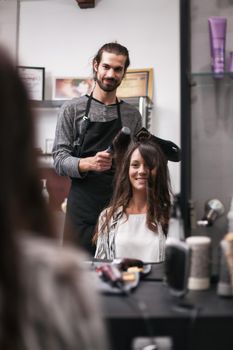 Young woman getting new hairstyle at professional hair styling saloon.