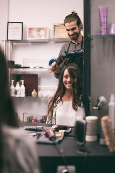 Young woman getting new hairstyle at professional hair styling saloon.