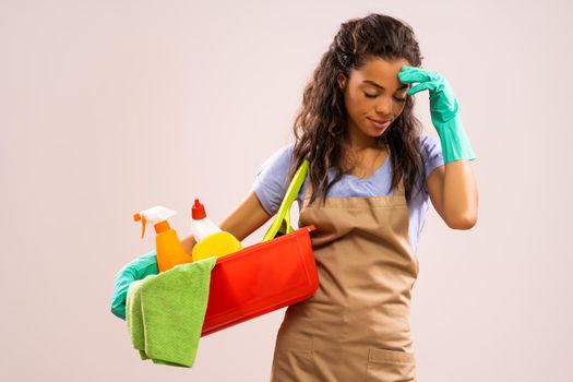 Portrait of african-american professional maid who is tired of cleaning.
