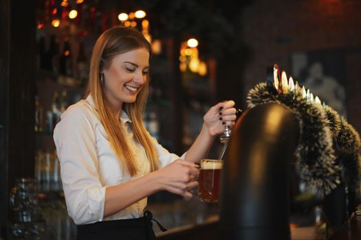 Portrait of happy woman who works as a bartender at bar.