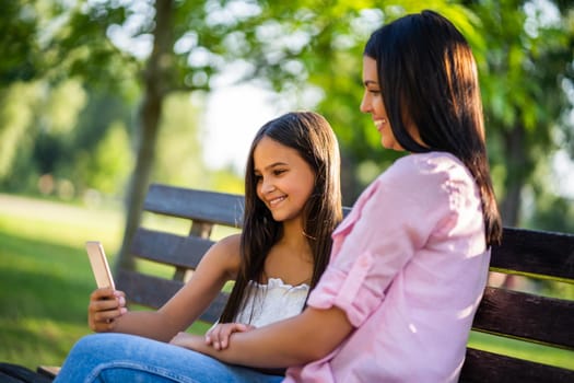 Happy family having nice time in park together. They are taking selfie.