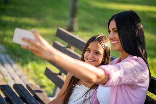 Happy family having nice time in park together. They are taking selfie.