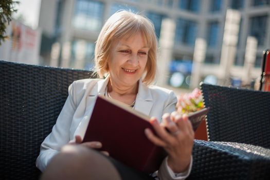 Senior businesswoman is sitting in cafe.