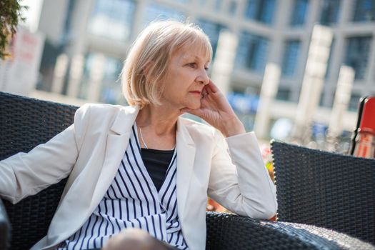 Senior unemployed businesswoman is sitting in cafe after getting fired.