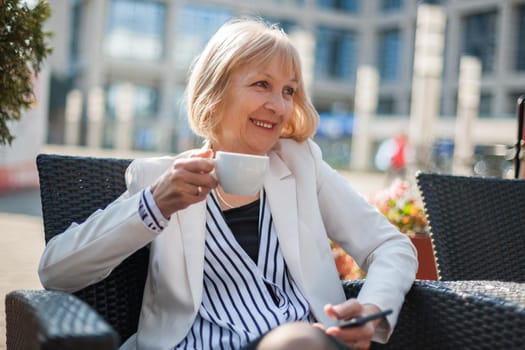 Senior businesswoman having coffee break in cafe