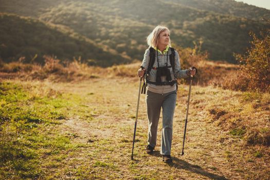 Senior woman is hiking in mountain. Active retirement.