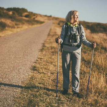 Senior woman is hiking in mountain. Active retirement.