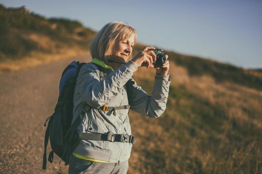Senior woman is hiking in mountain. Active retirement.